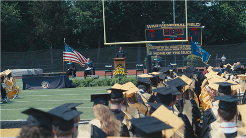 Picture of graduates listening to principal speaking at CB West graduation ceremony 2025